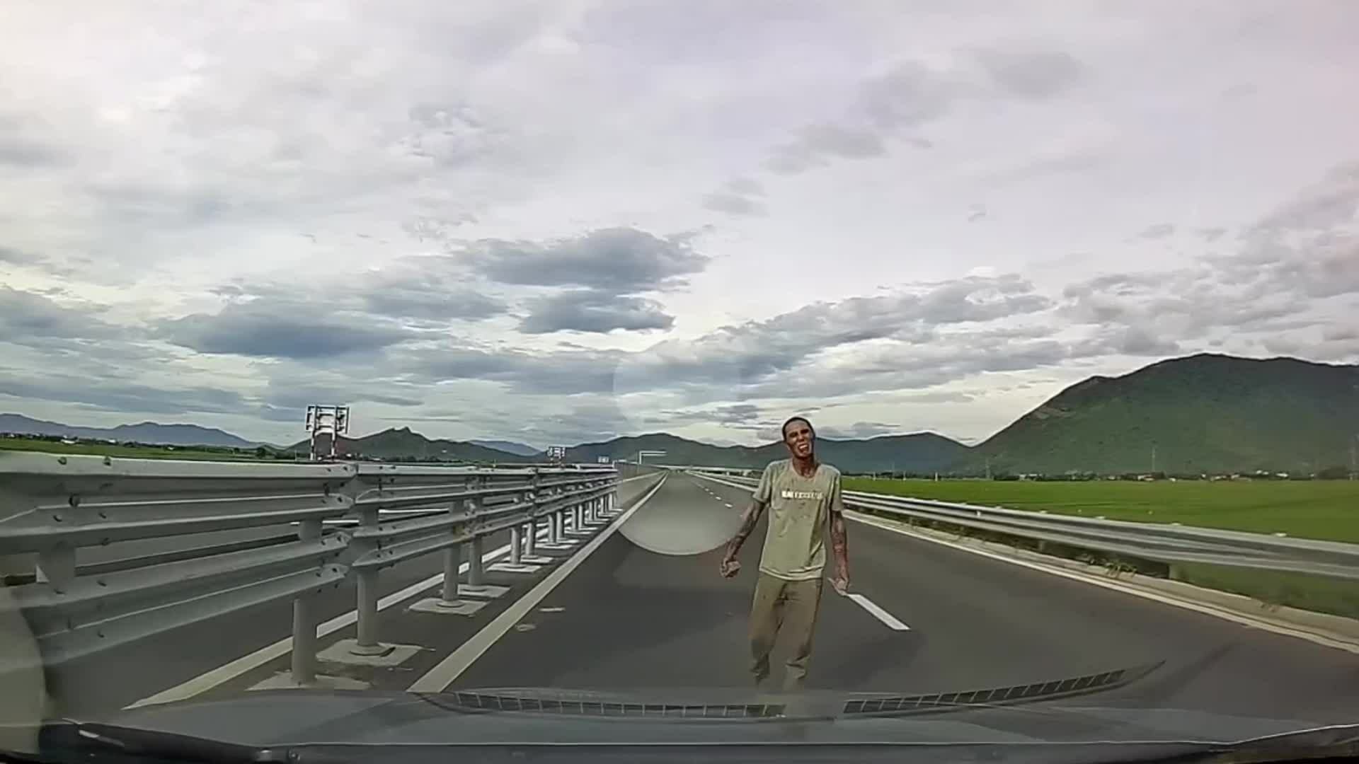 青年持石头在云峰-芽庄高速公路上拦车