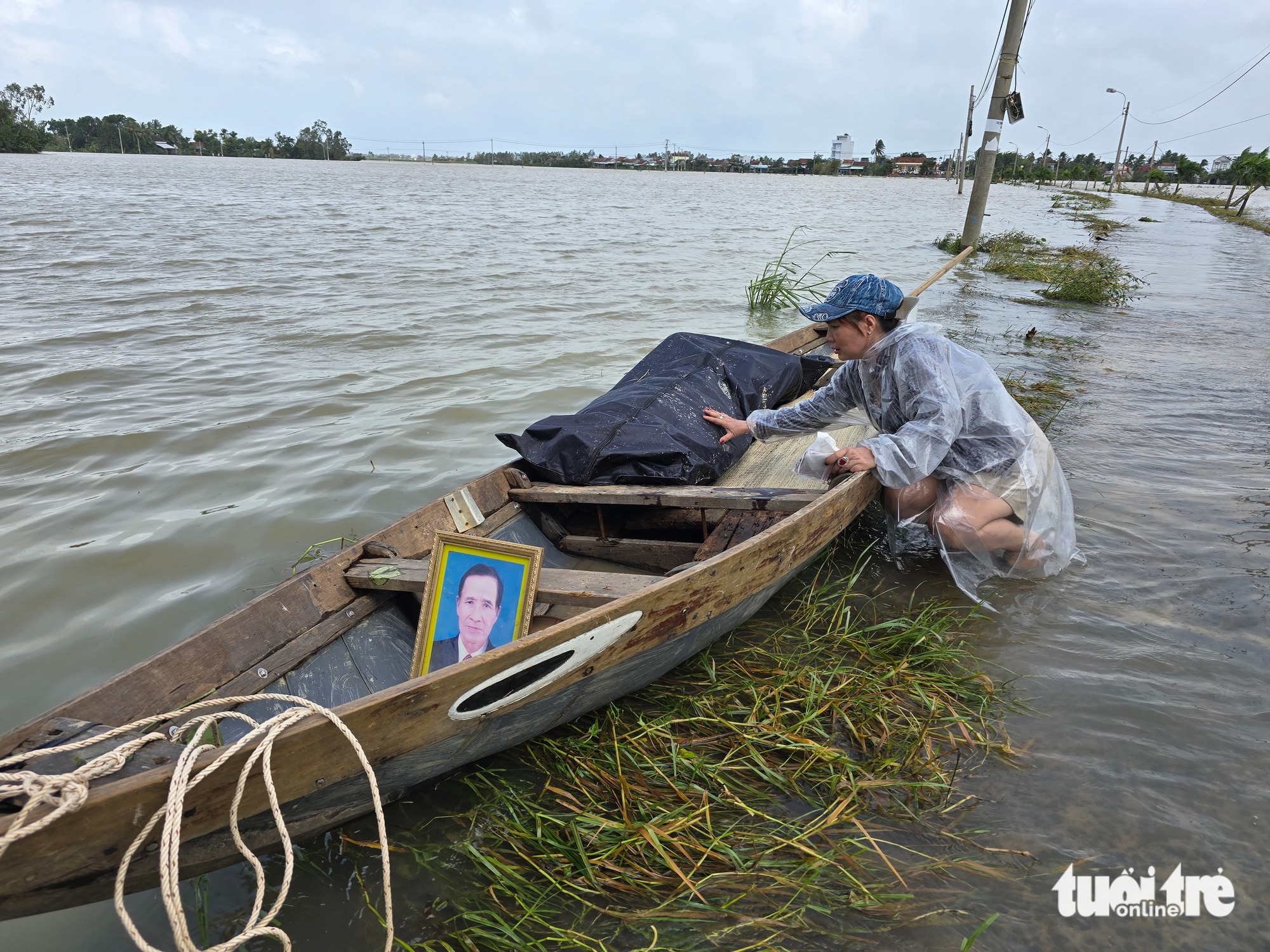 女儿在运送父亲遗体的船旁痛苦等待，在和平春的洪水中等待棺材