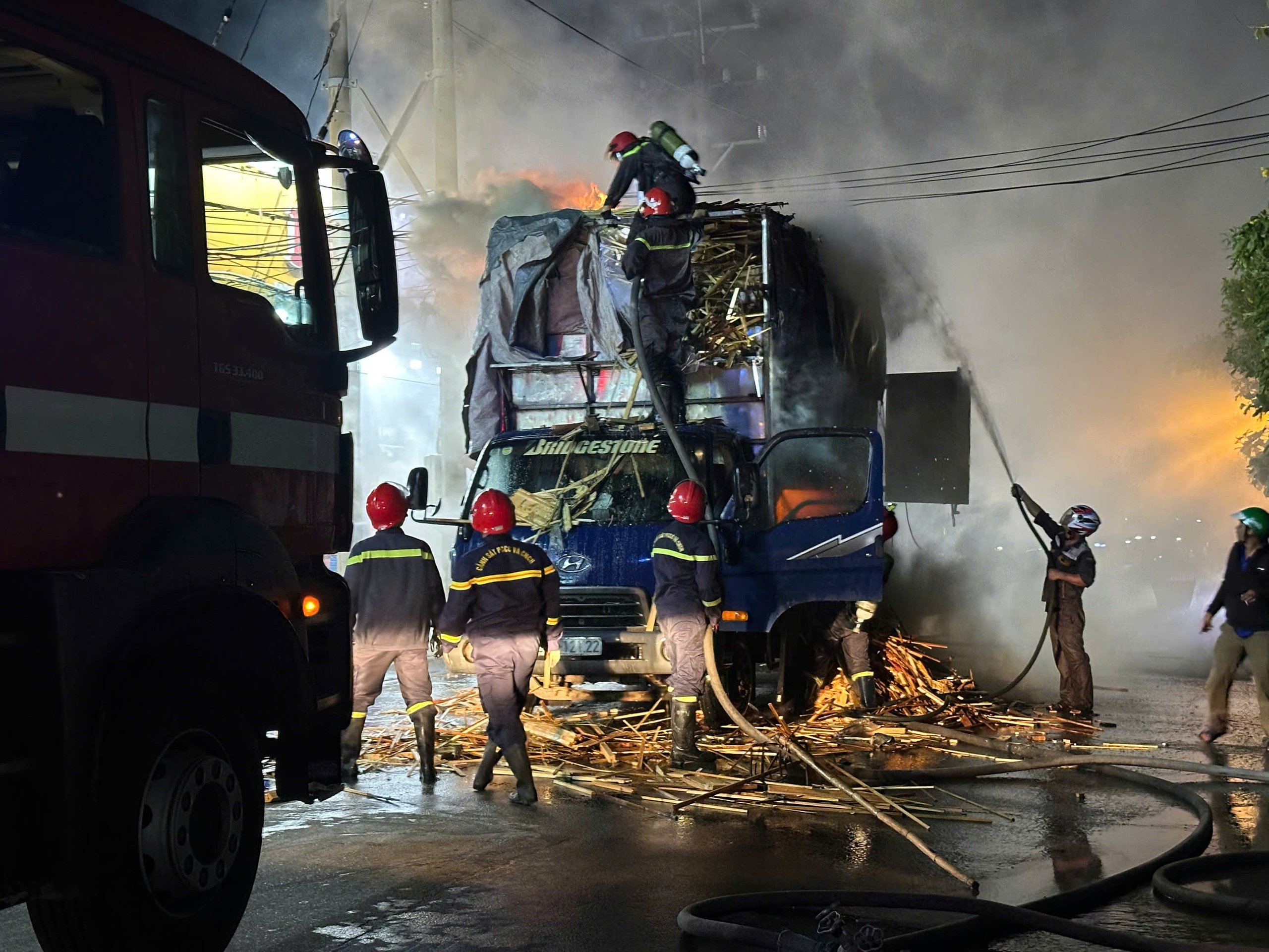 运木卡车起火，警察戴防毒面具灭火