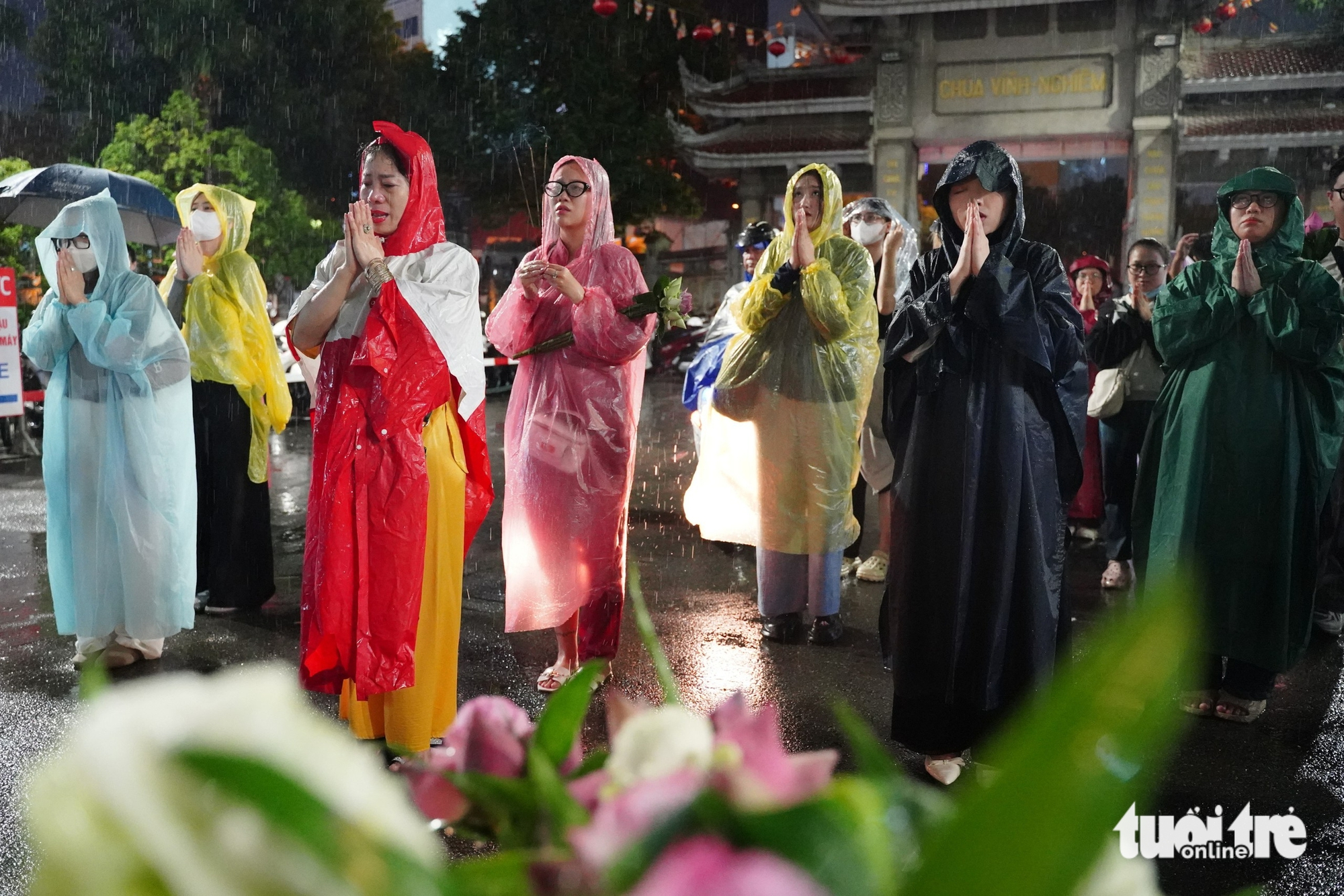 胡志明市市民冒雨在盂兰节期间参拜寺庙