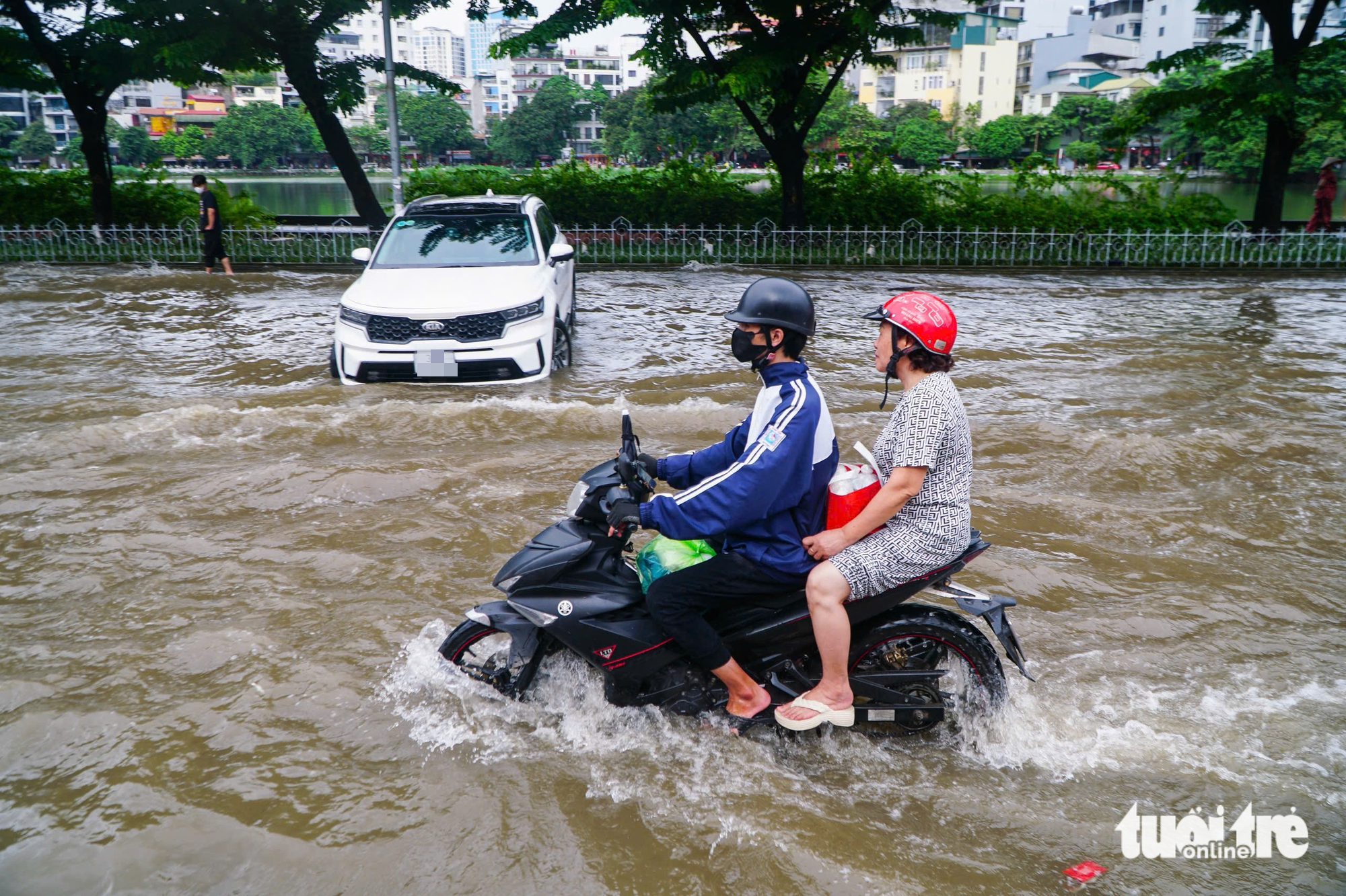 河内各地仍积水严重，修车工在积水点“驻扎”修理熄火车辆