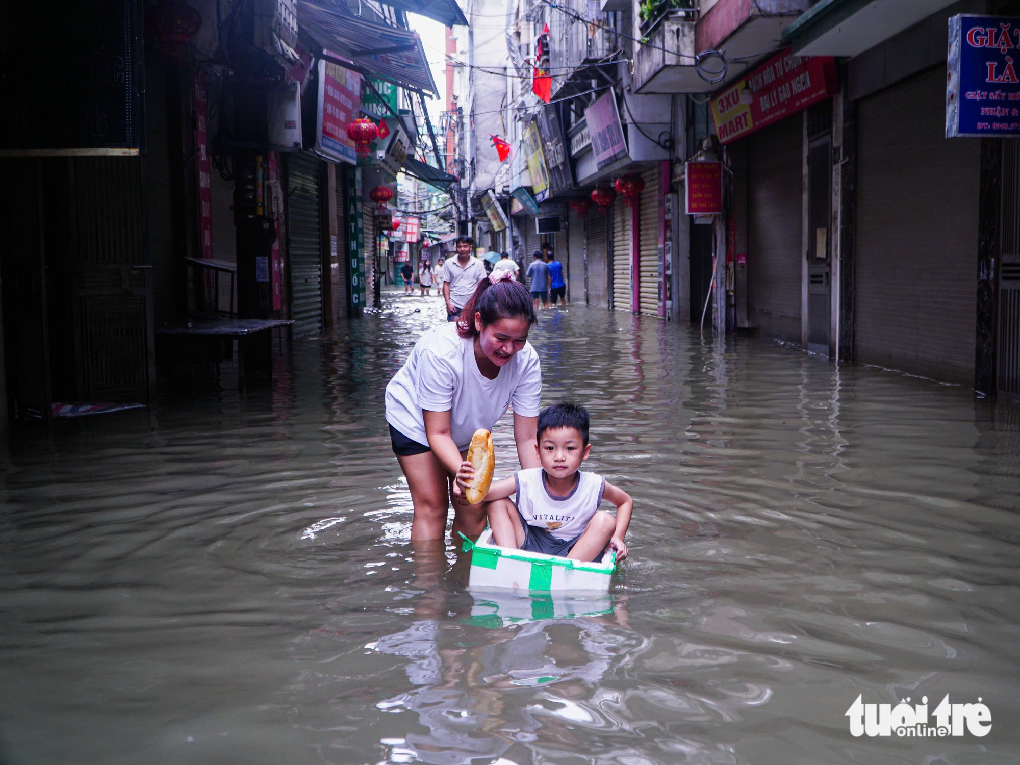 河内市民在洪水中艰难应对，有地方需用梯子爬进家门