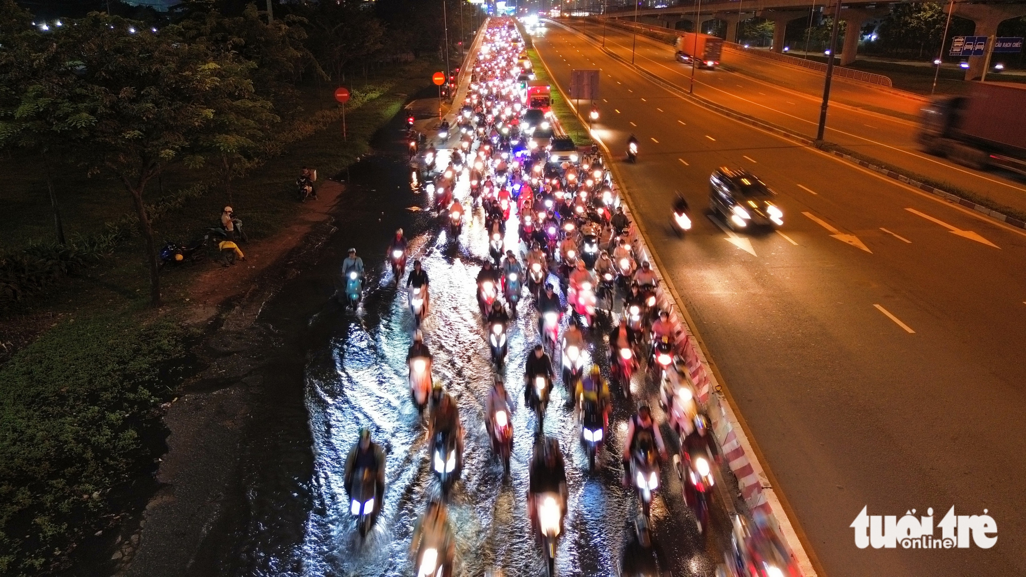 潮汐导致武元甲路下水道水漫路面，数千摩托车缓慢通过积水路段