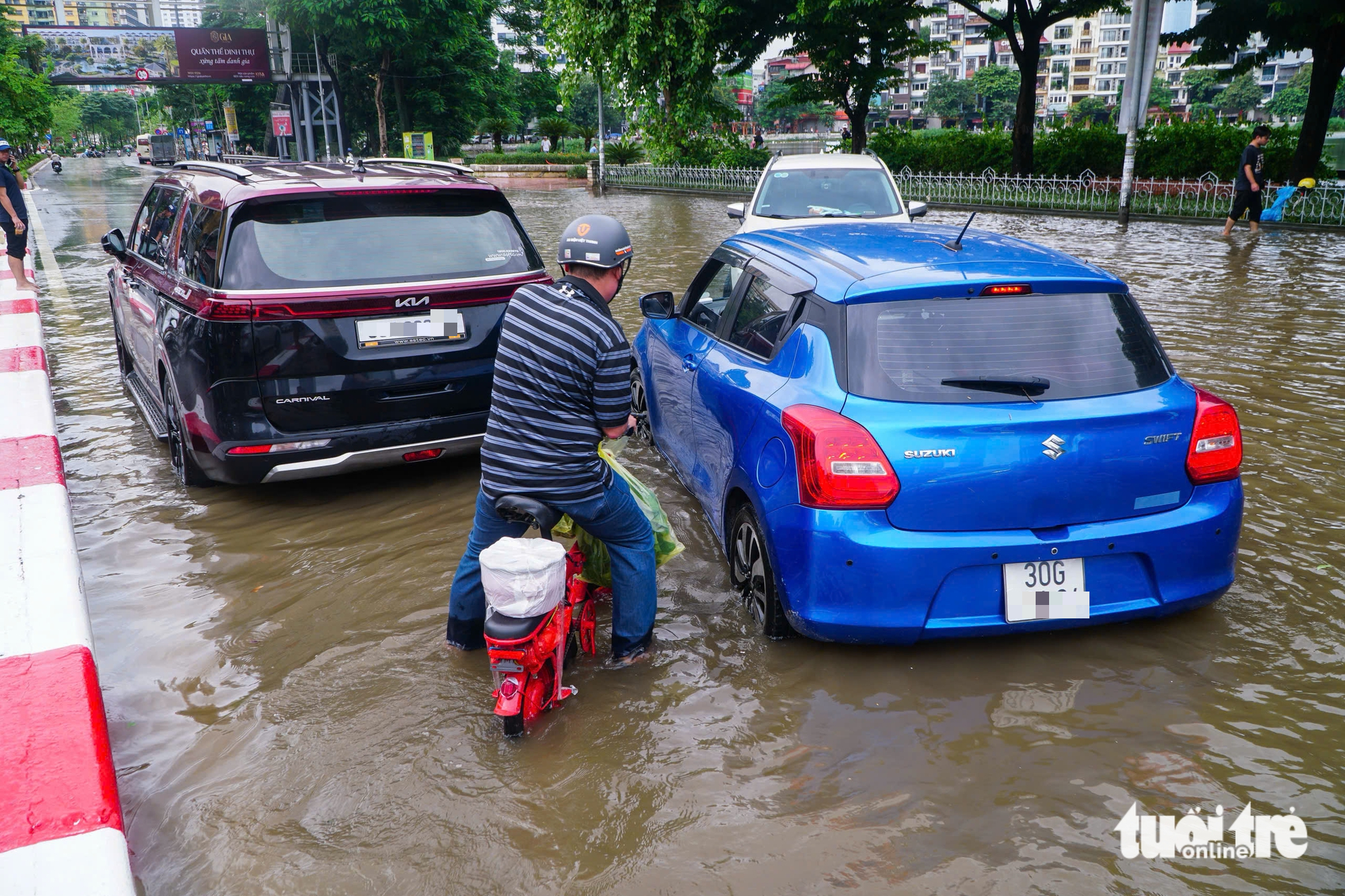 河内各地仍积水严重，修车工在积水点“驻扎”修理熄火车辆