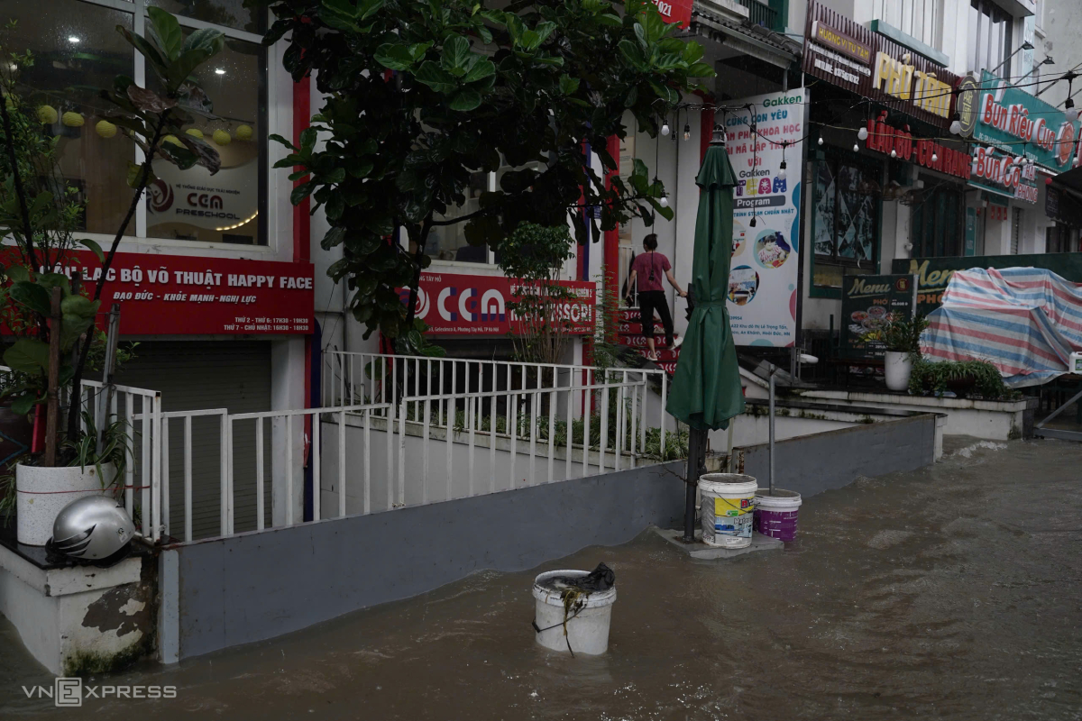 居民在桥下避雨，涉水寻找回家路