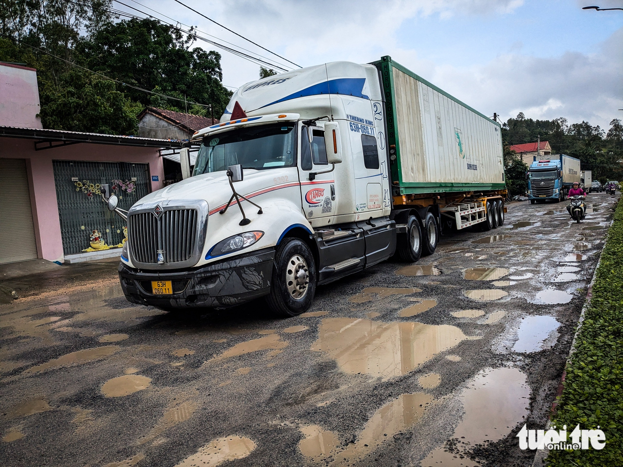 洪水过后国道1号多处路段损毁严重，车辆缓慢前行