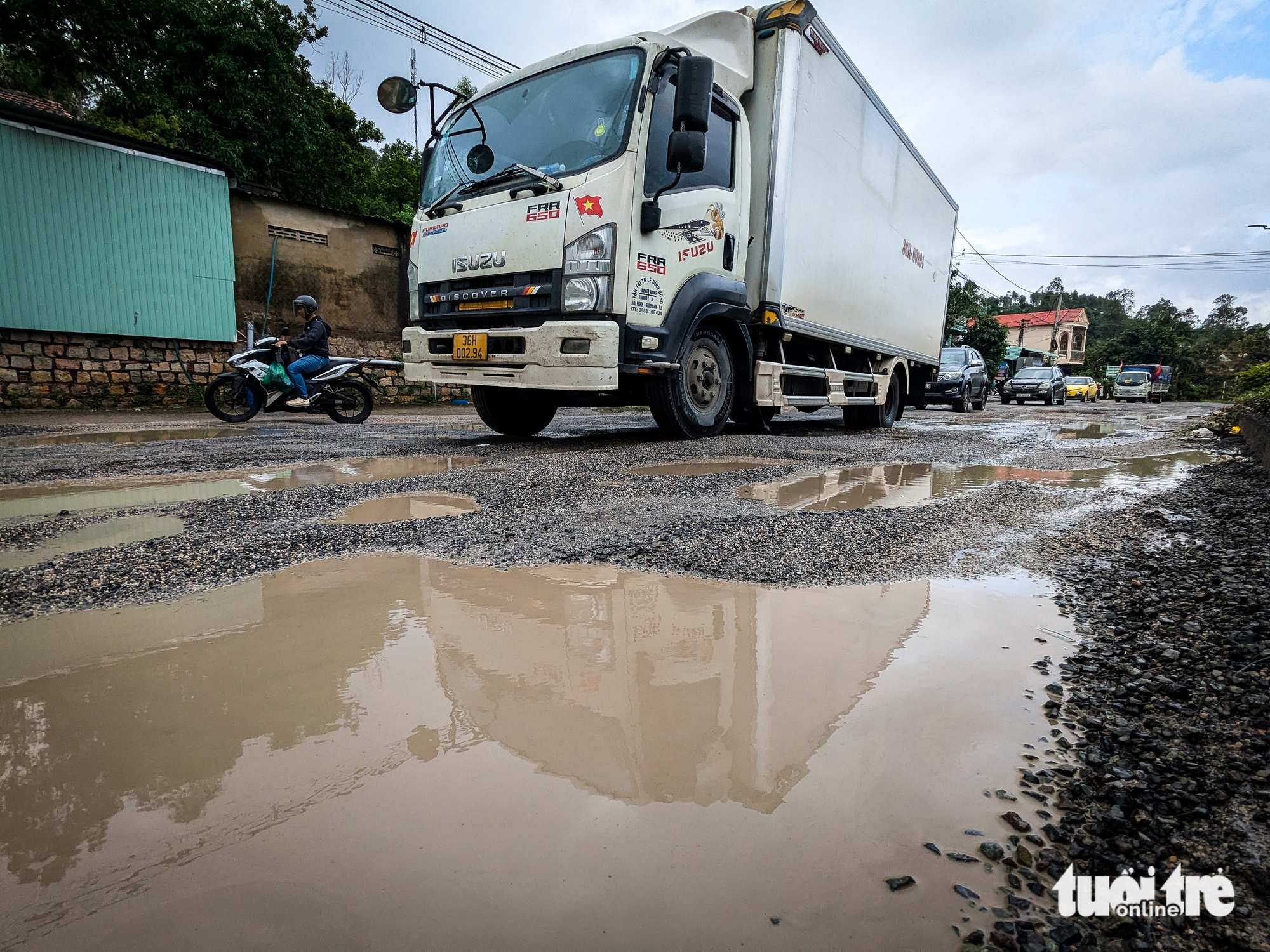 洪水过后国道1号多处路段损毁严重，车辆缓慢前行