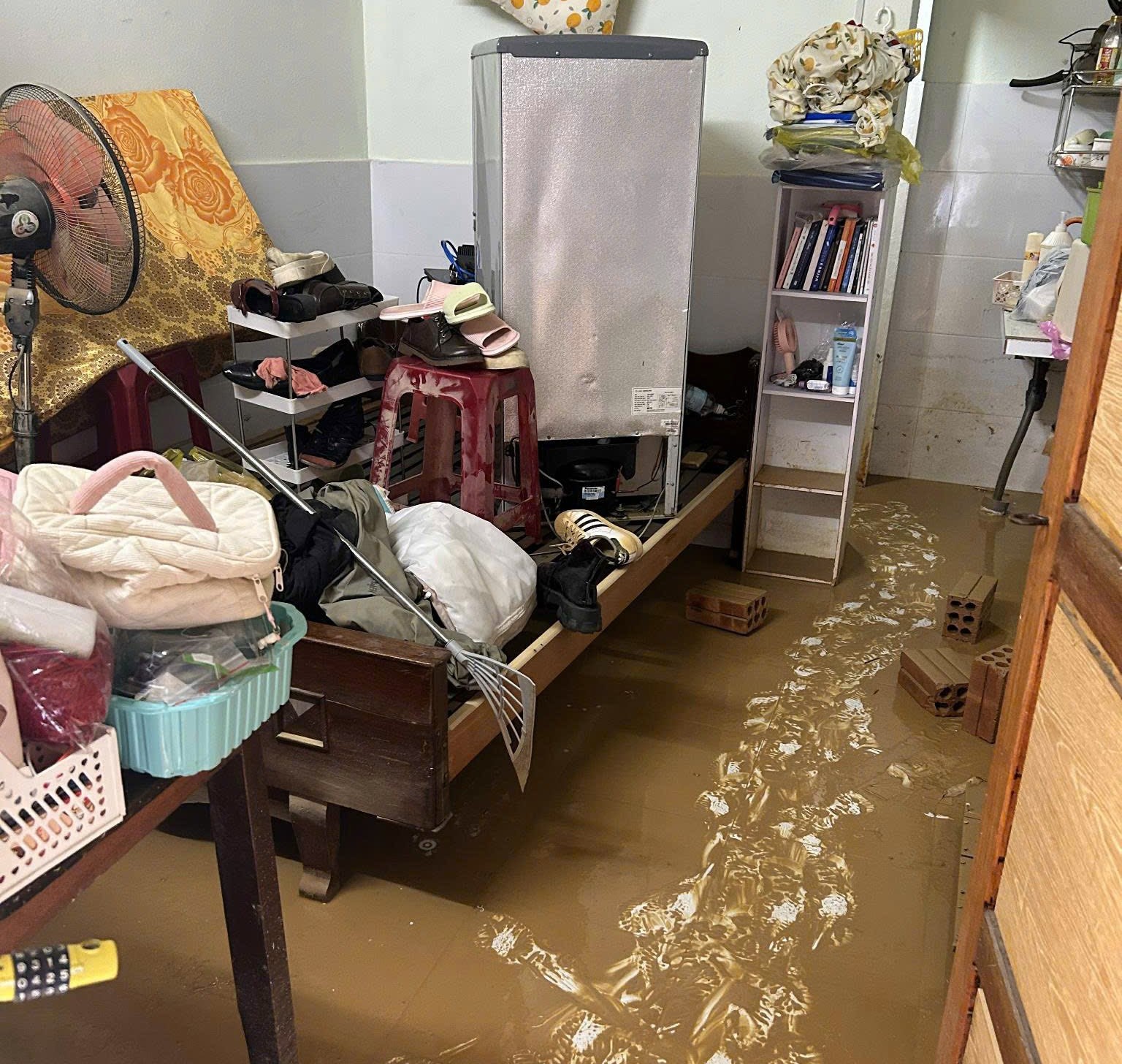 面对一片狼藉的出租屋，学生书籍淹没在洪水中，令人心酸