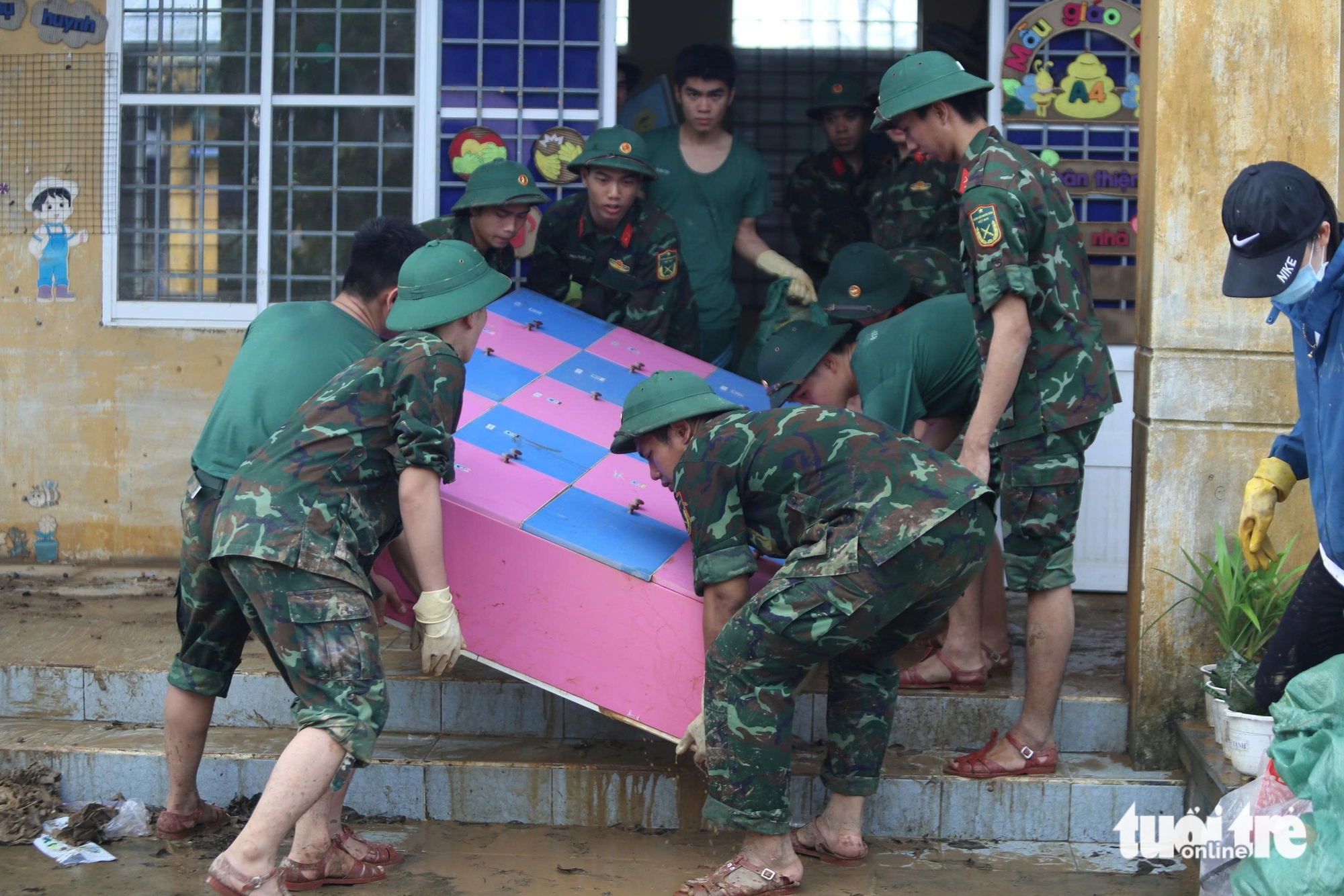 老师们搁置家务，在洪水后涉泥清理学校