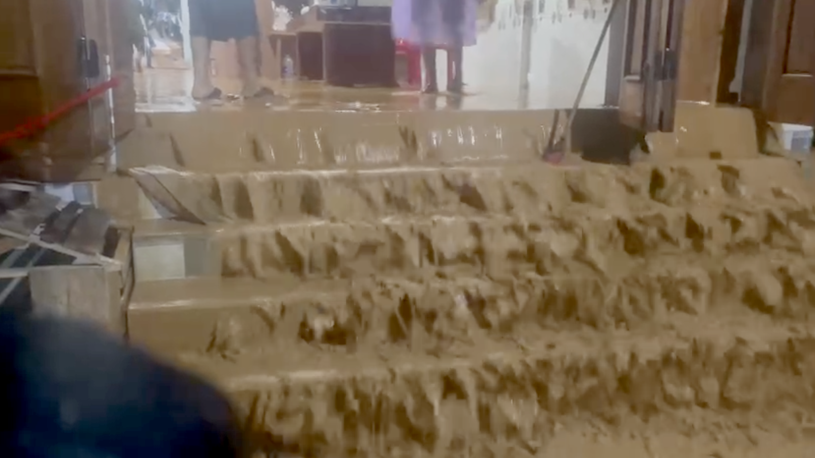 泥浆洪水如瀑布般涌入房屋，警察必须翻墙进入紧急疏散居民