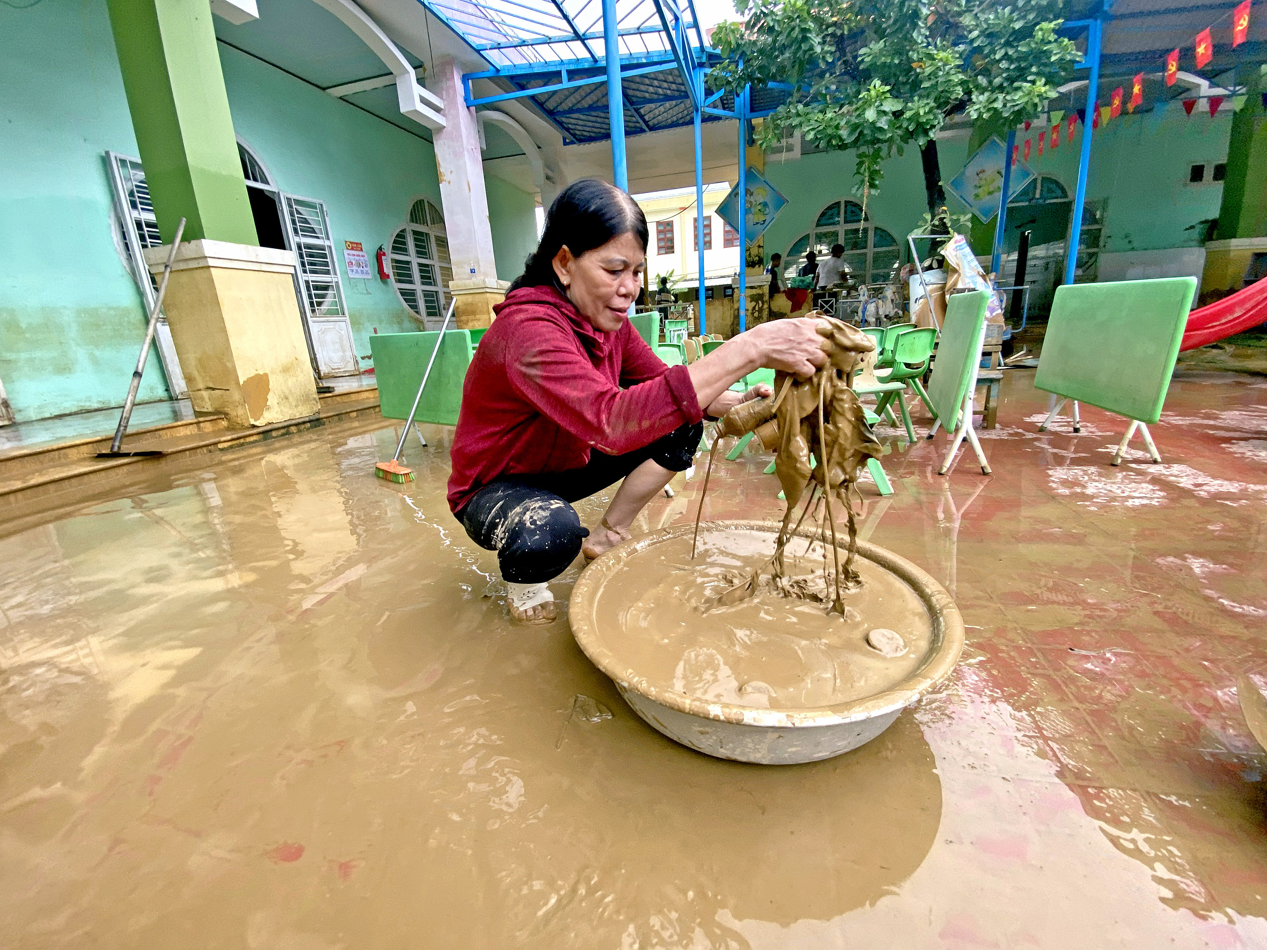 心痛！岘港洪水中心区教师清洗层层淤泥为学生寻找学习用品