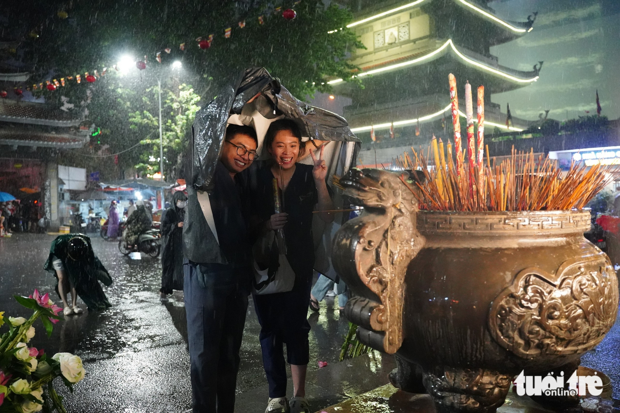 胡志明市市民冒雨在盂兰节期间参拜寺庙