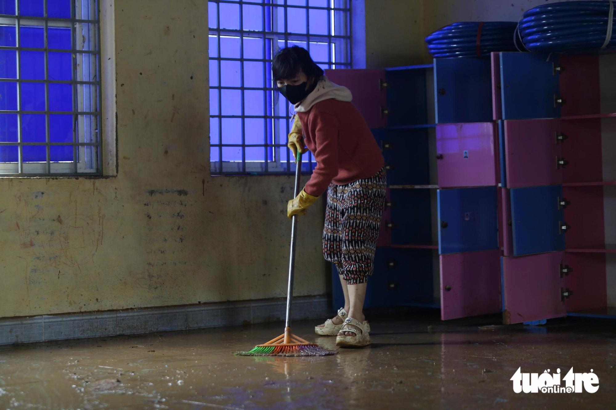 老师们搁置家务，在洪水后涉泥清理学校