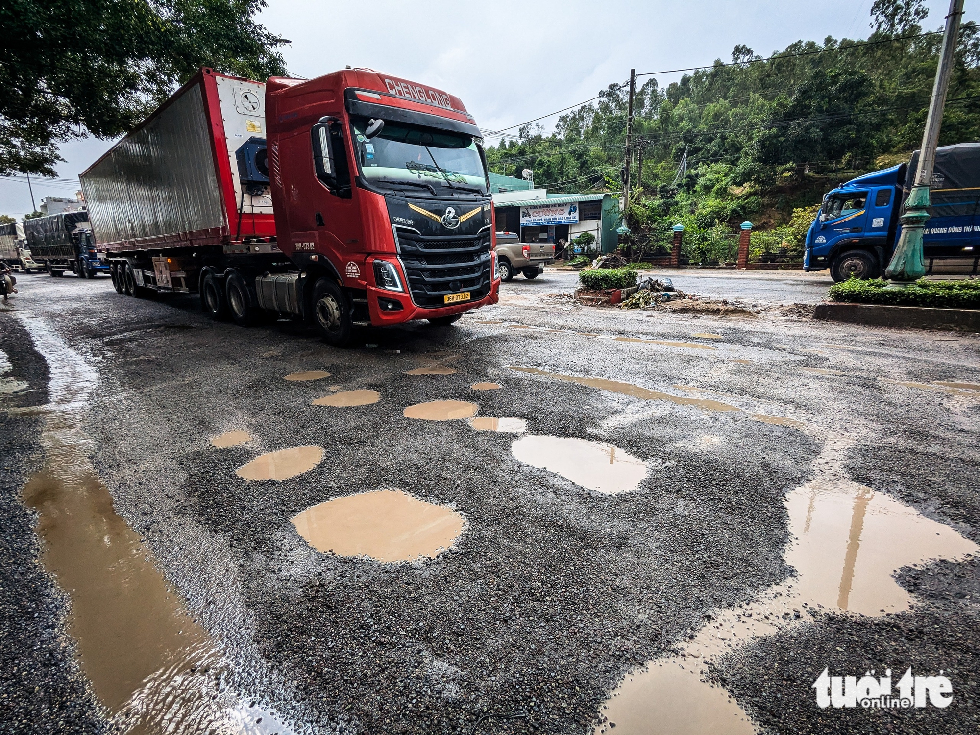 洪水过后国道1号多处路段损毁严重，车辆缓慢前行