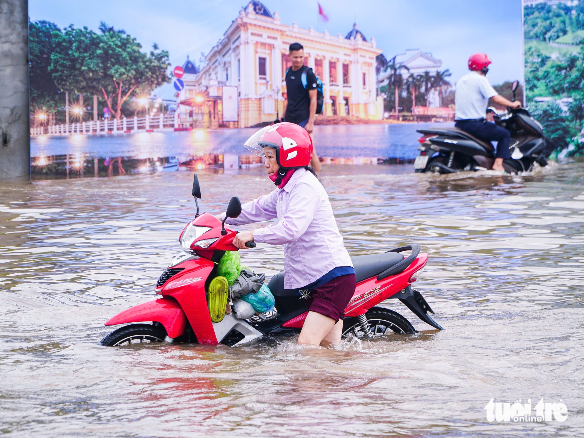 河内市民在洪水中艰难应对，有地方需用梯子爬进家门