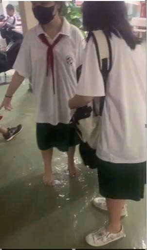 胡志明市一所学校每逢大雨就积水，老师们必须舀水